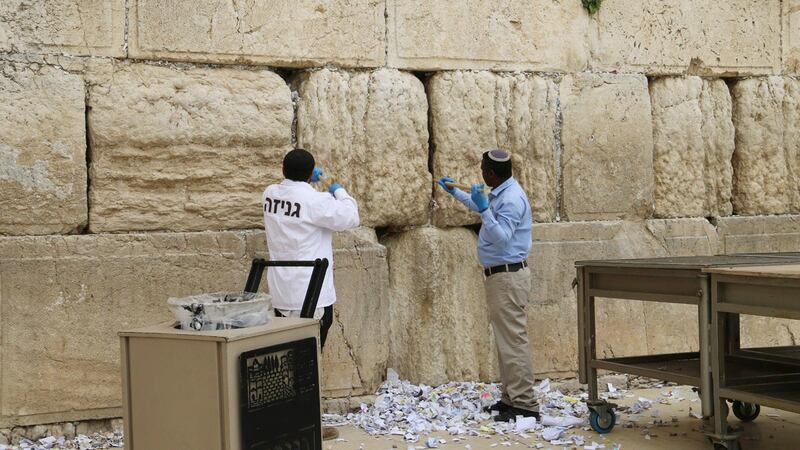 Västra muren i Jerusalem sanerades på tisdagen mot coronaviruset samtidigt som tiotusentals bönelappar plockas bort ur murens springor.