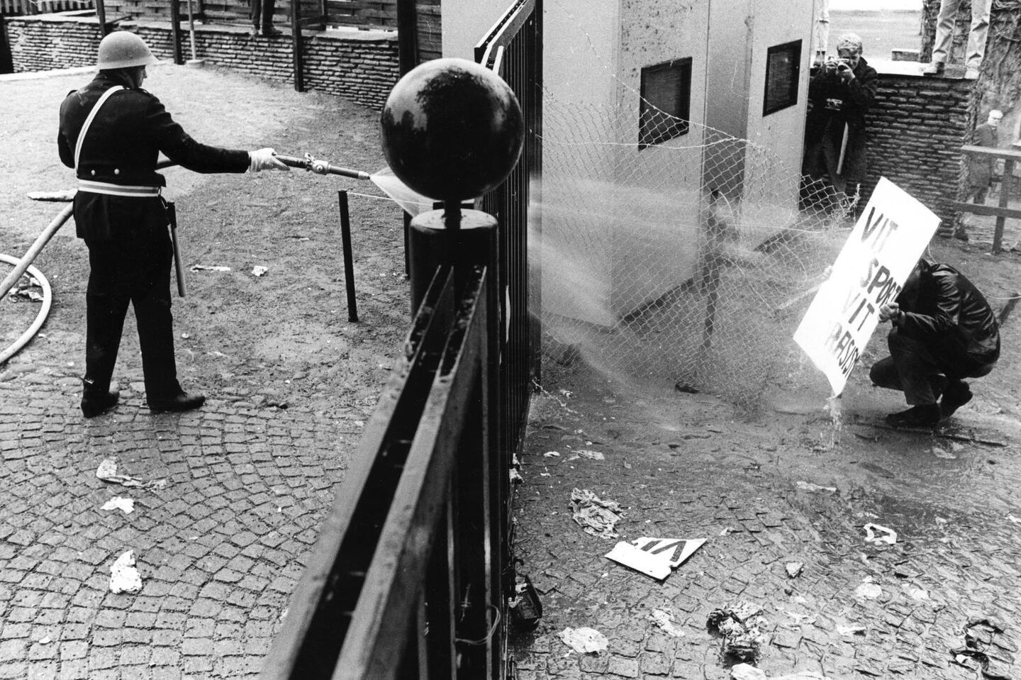 Polisen sprutar vatten på demonstrant vid den norra grinden till tennisarenan under kravallerna i Båstad, då demonstranter stoppade tennismatchen mellan Sberige och Rhodesia.