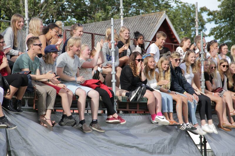 Festivalbesökare på läktaren beskådar färgkampen.