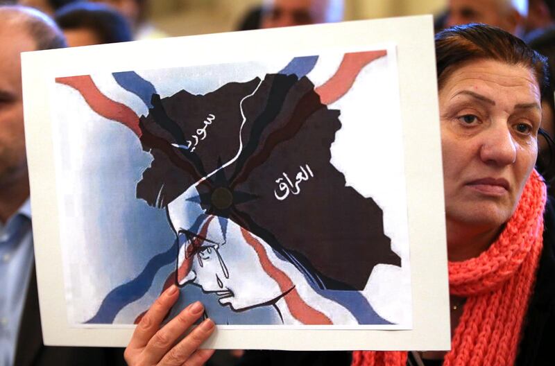 En assyrisk kvinna från Irak, som tvingats fly från Mosul, protesterar i en kyrka i Libanon mot Islamiska staten.  