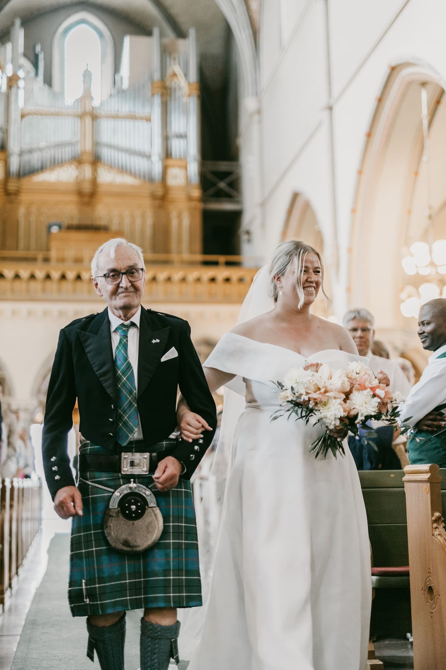 Elise Ralston Samuelson går arm i arm med sin pappa Hamish Ralston fram till altaret under vigseln.