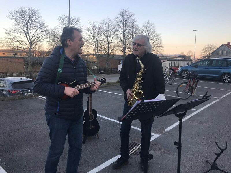 Per Hoverstam och Kennert Orlenius sjunger och spelar innan maten delas ut utanför pingstkyrkan i Mölndal.