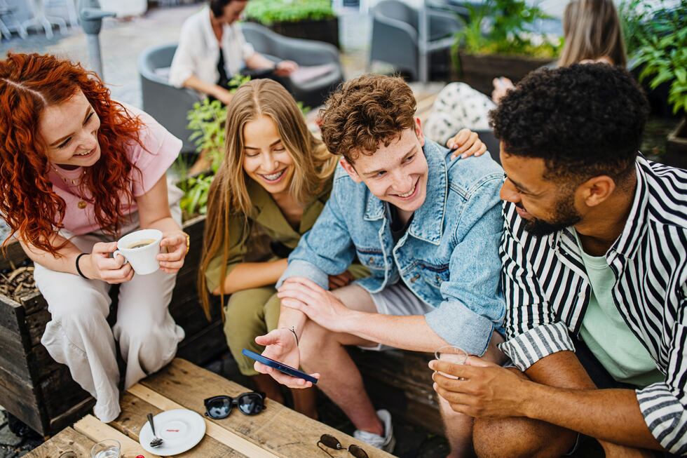 Getty images Unga vänner sitter vid ett café.