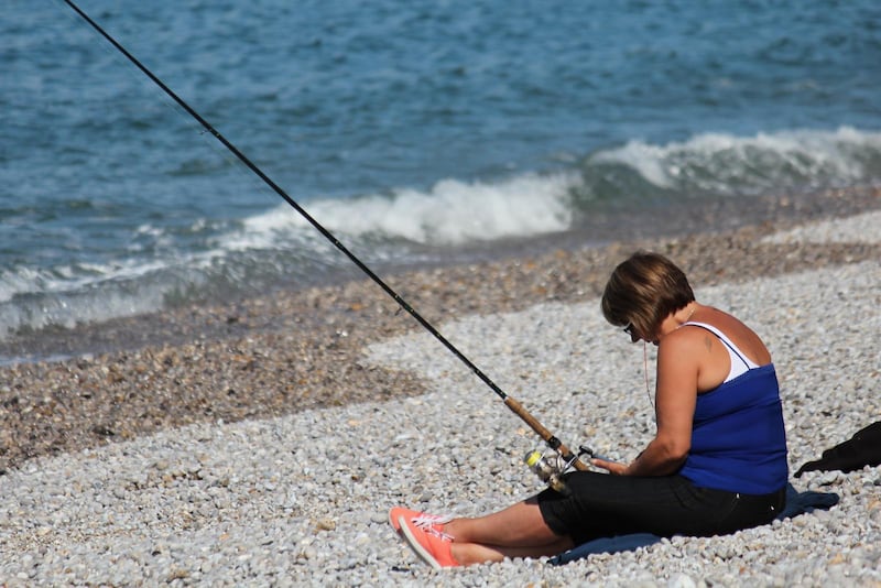 Atlantfiske på stenstranden i Étretat.