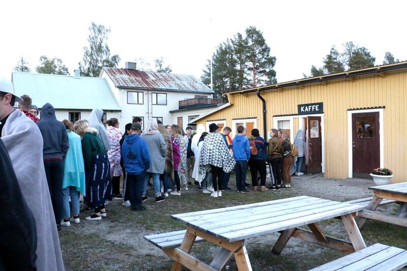 Ungdomar i kö till nattcaféet. I nattkylan har en del virat in sig i filtar.