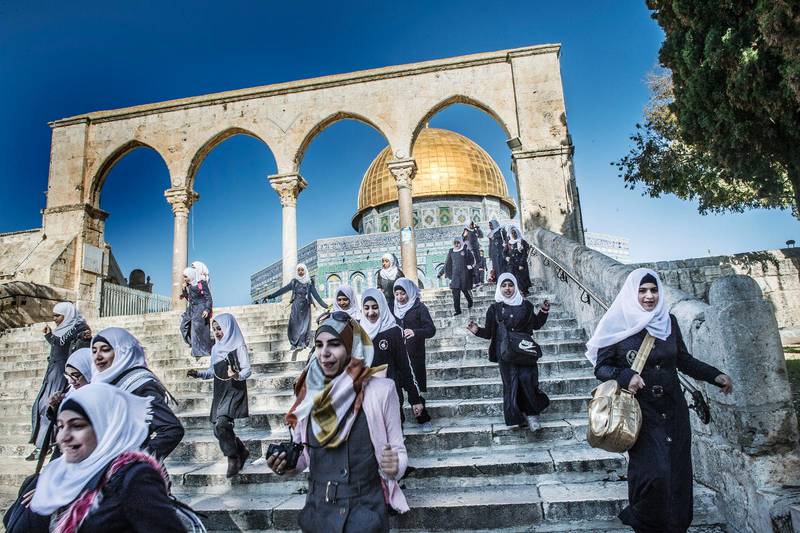 Helig plats. Unga kvinnor springer nedför en trappa på Tempelberget i Jerusalem. Klippdomen i bakgrunden.
