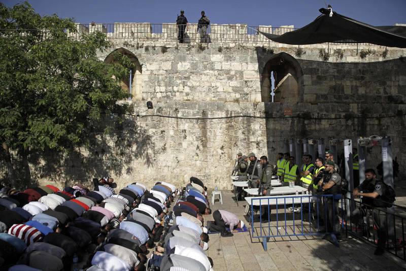 Muslimer ber utanför de Israeliska säkerhetskontrollerna, som av många av dem betraktas som en kräkning, vid Tempelberget.