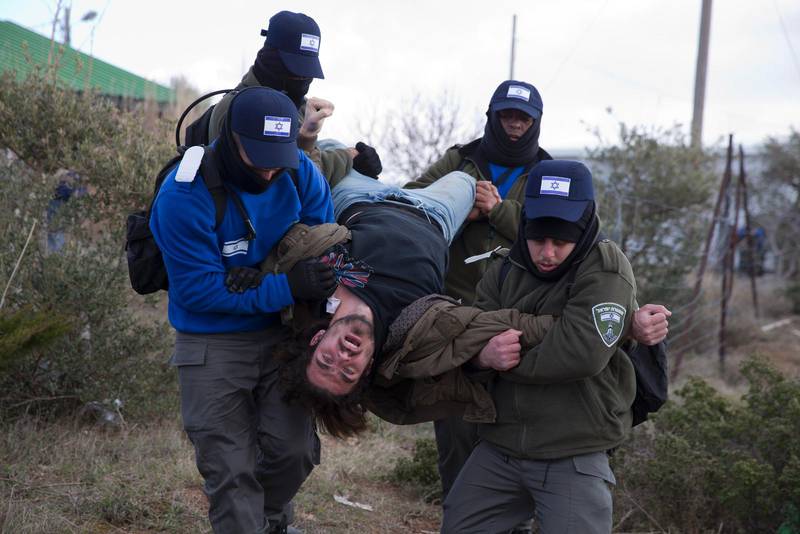 Israelisk polis arresterar en bosättare.