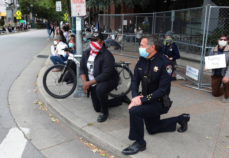 Polischefen och borgmästaren i Santa Cruz, USA, går ner på knä ihop med demonstranter för att minnas George Floyd.