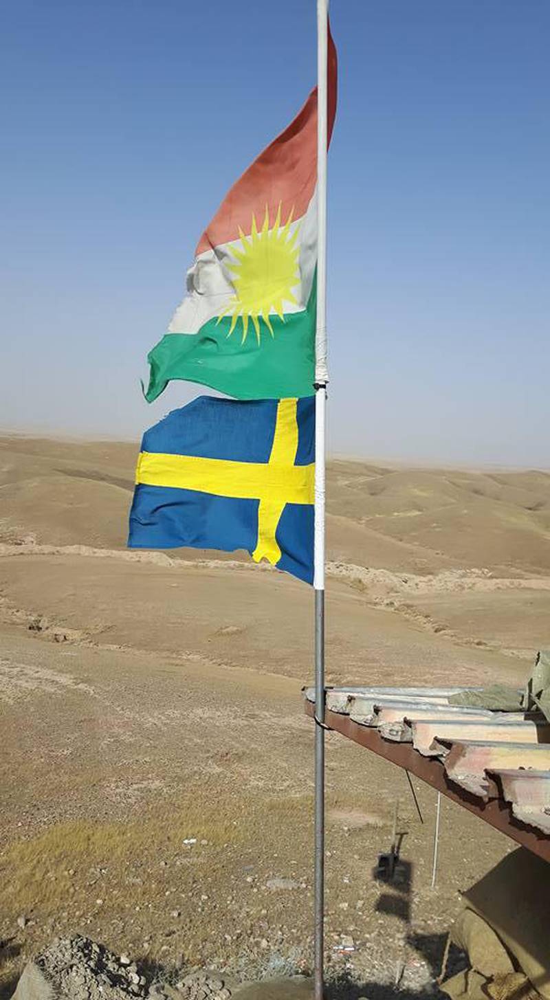 Den kurdiska och svenska flaggan vajar i vinden.