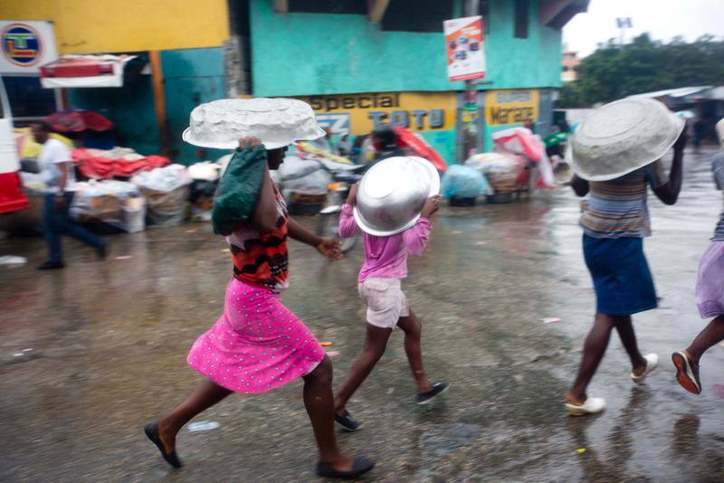 Kvinnor försöker skydda sig från regnet i Port-au-Prince när orkanen Matthew drabbade Haiti.